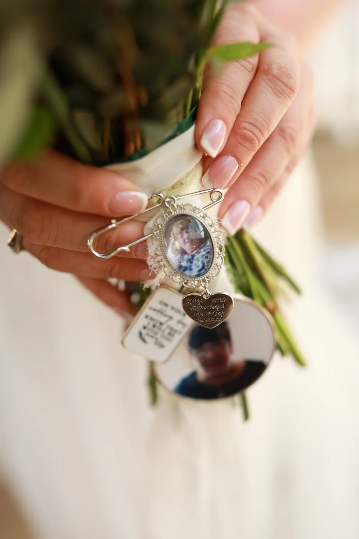 A small memorial locket held among the flowers of a wedding bouquet