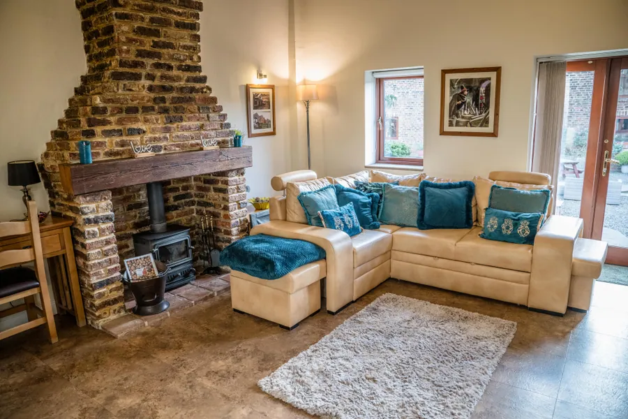 A cottage living room with a brick chimney and log burner