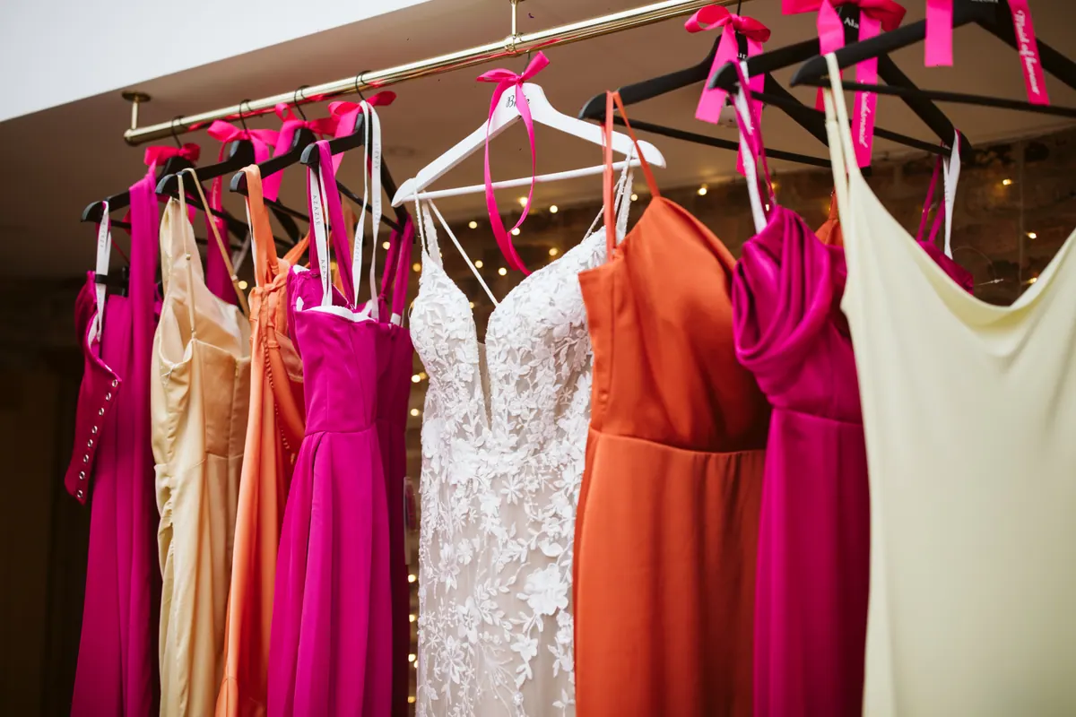 Colourful dresses arranged around a white wedding dress
