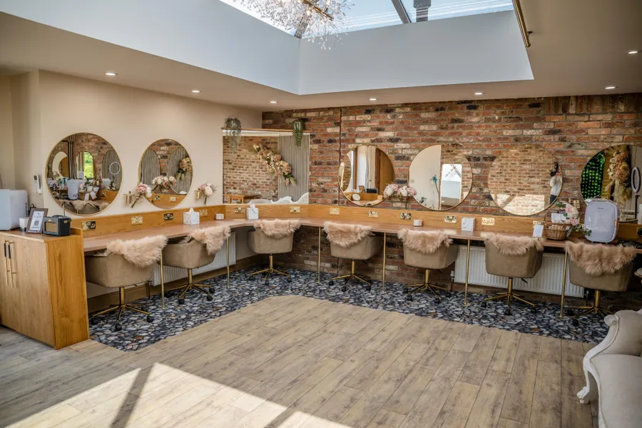 A makeup room with illuminated mirrors beneath a glazed roof